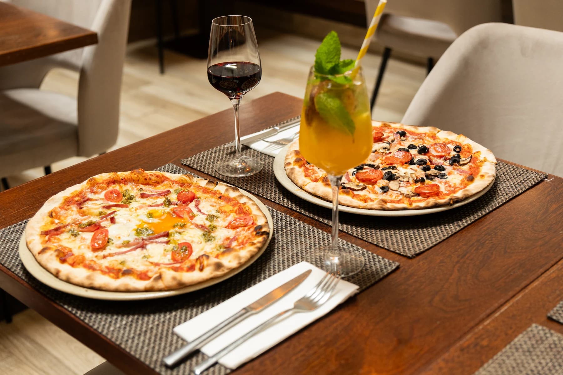 Mesa com pizzas artesanais, vinho e cocktail na Nonna Piazza